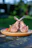 Close-up of a perfectly cooked lamb rib with a rustic wooden background.