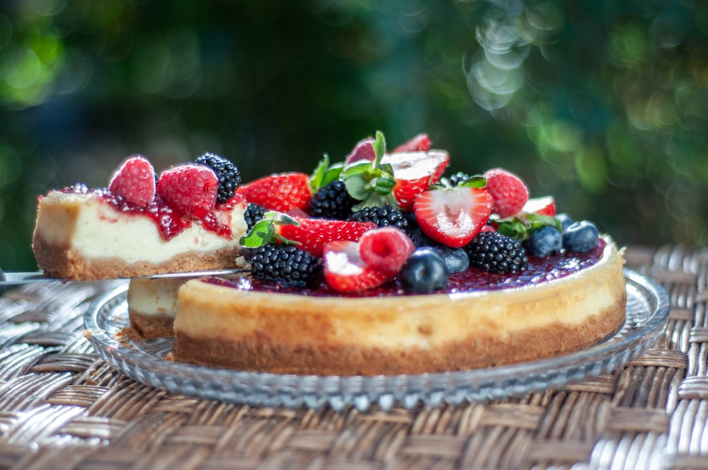 a cheesecake topped with berries and blueberries on a plate
