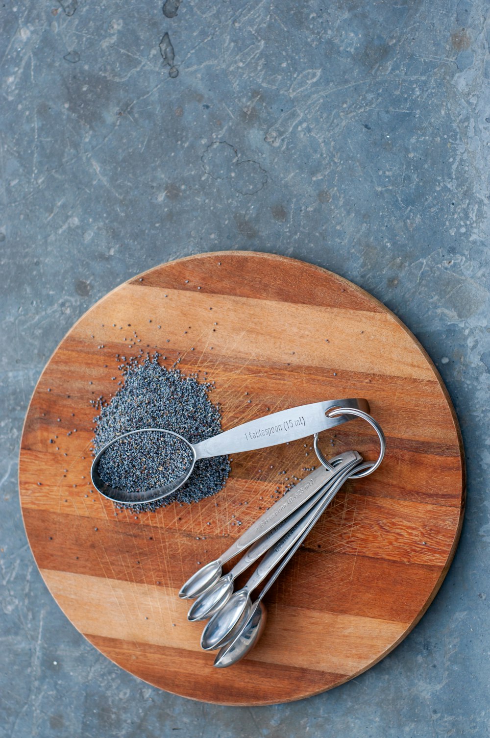 a wooden cutting board topped with metal spoons