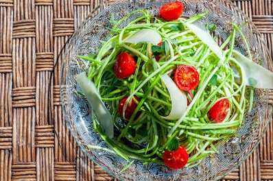 a glass bowl filled with a salad of green beans and tomatoes