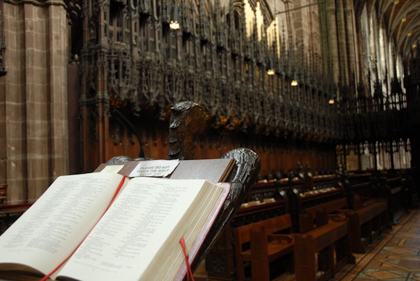 A close-up of an open Bible resting on a wooden lectern.