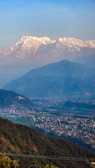 Snow-capped peaks of the Himalayas seen from a peaceful mountain village.