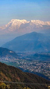 Snow-capped Himalayan peaks framing a cozy mountain village in Kashmir.