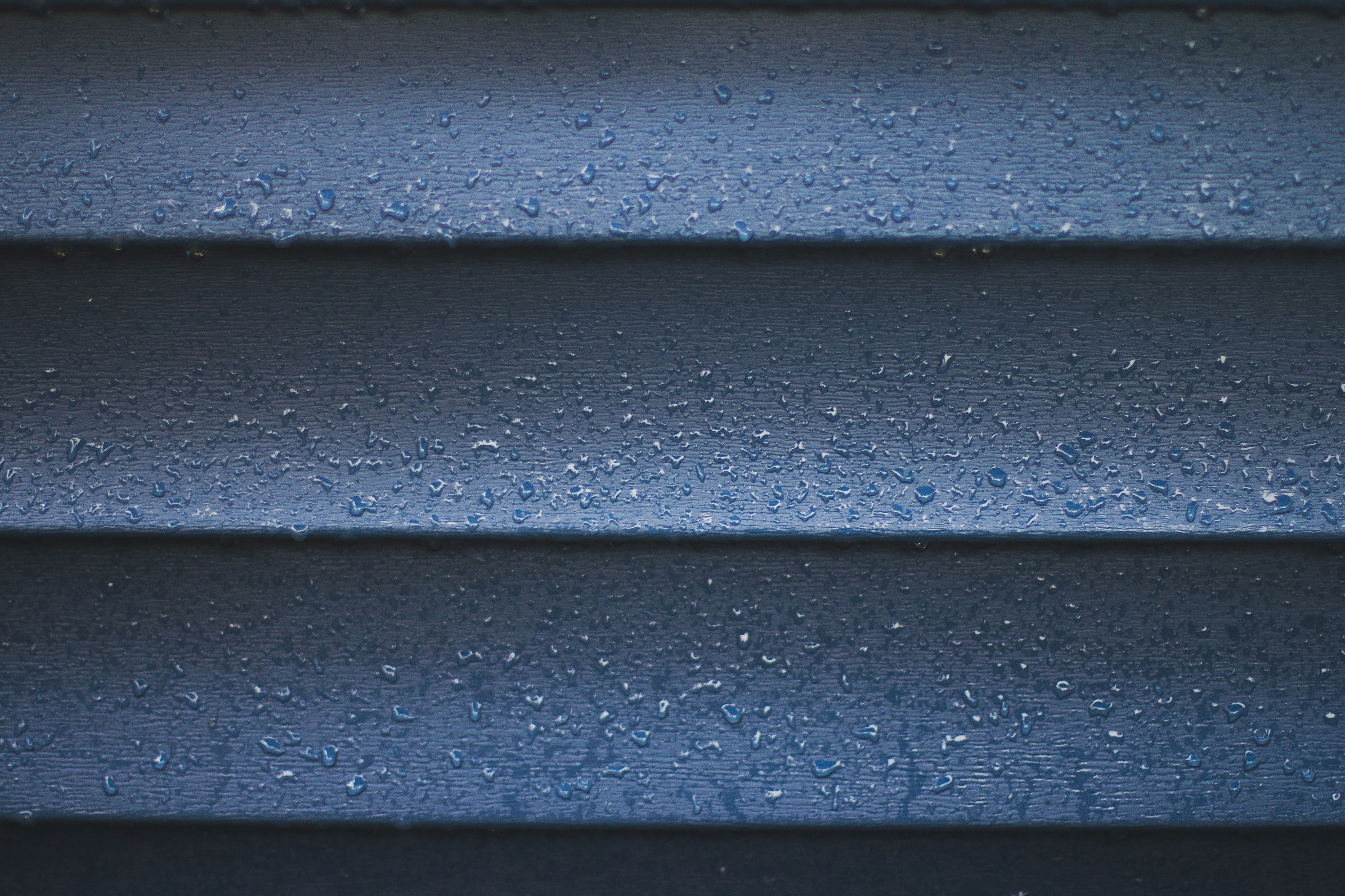 a close up of a blue wall with water droplets
