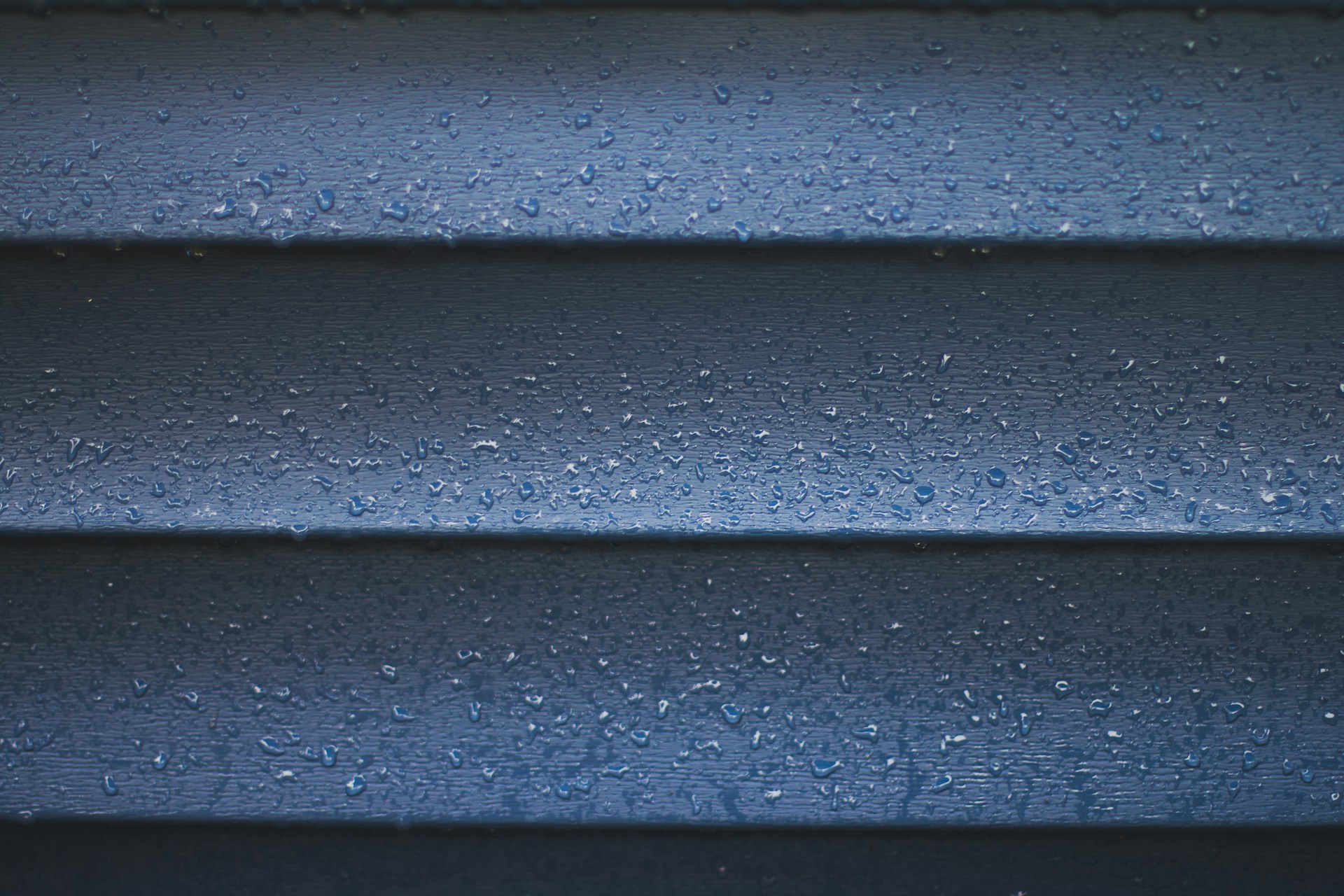 a close up of a blue wall with water droplets