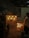 An industrial setting with various machinery. There is a control panel with several glowing bulbs and meters. A rack with multiple glowing lights is placed next to it. A person is partially visible on the right side of the image. A smoky or foggy atmosphere adds a dim ambiance to the scene.