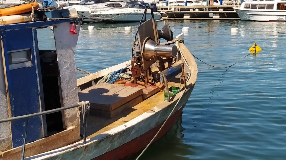 a boat docked in a harbor with other boats in the background