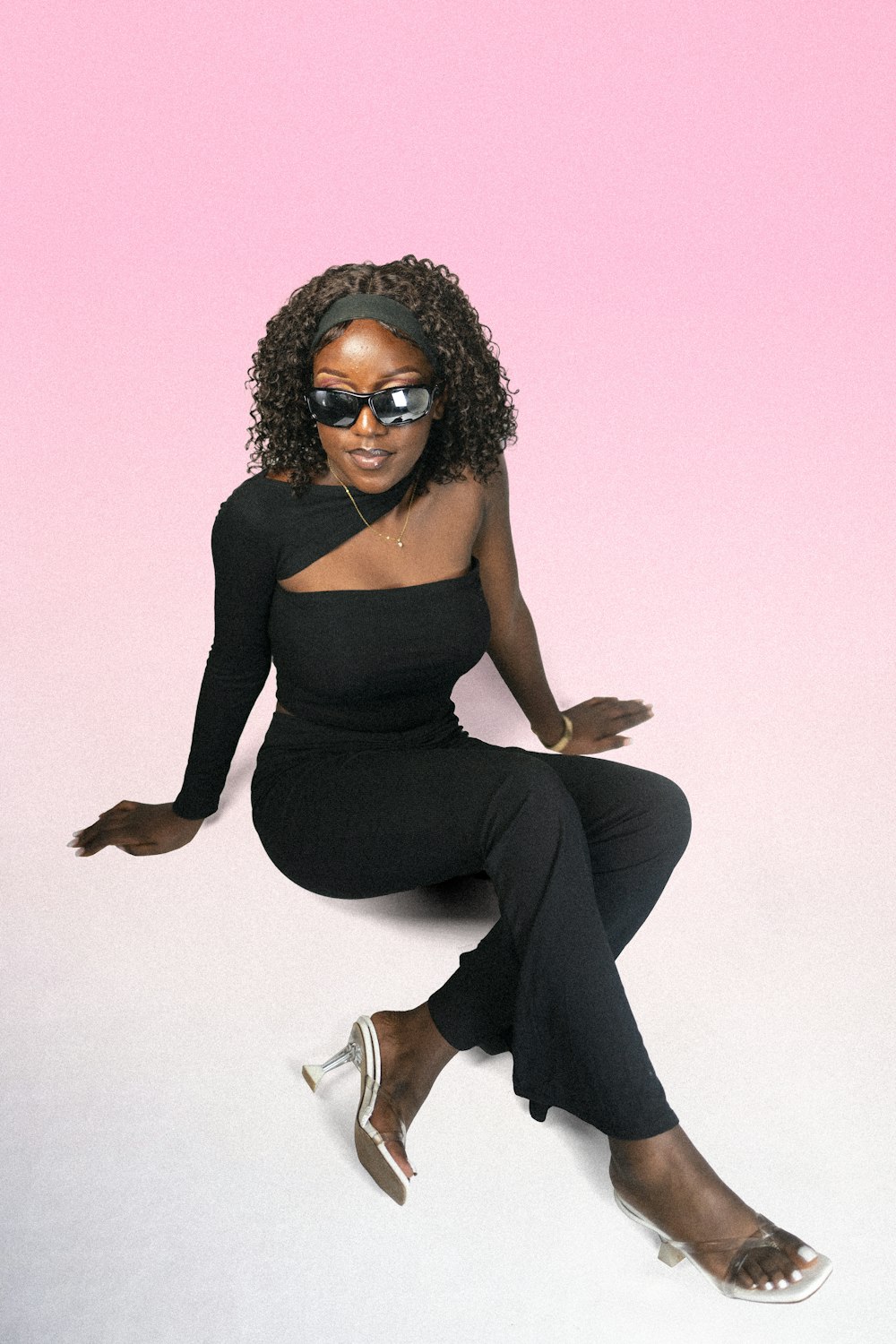 a woman sitting on the ground wearing sunglasses