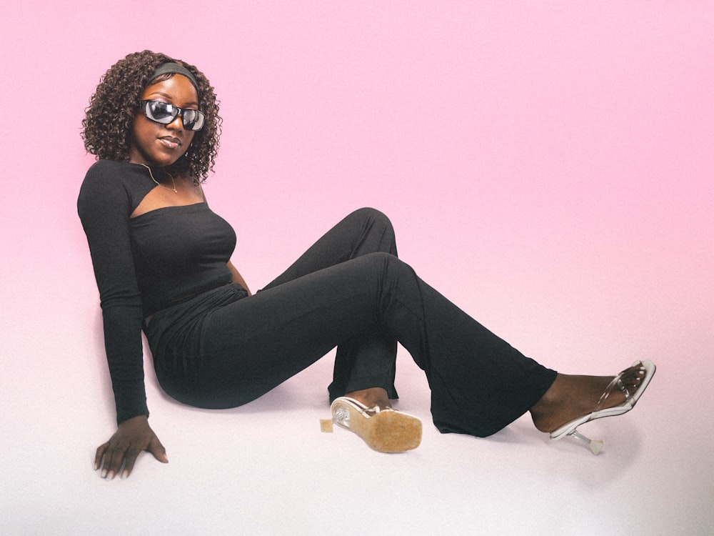 a woman sitting on the ground with her legs crossed