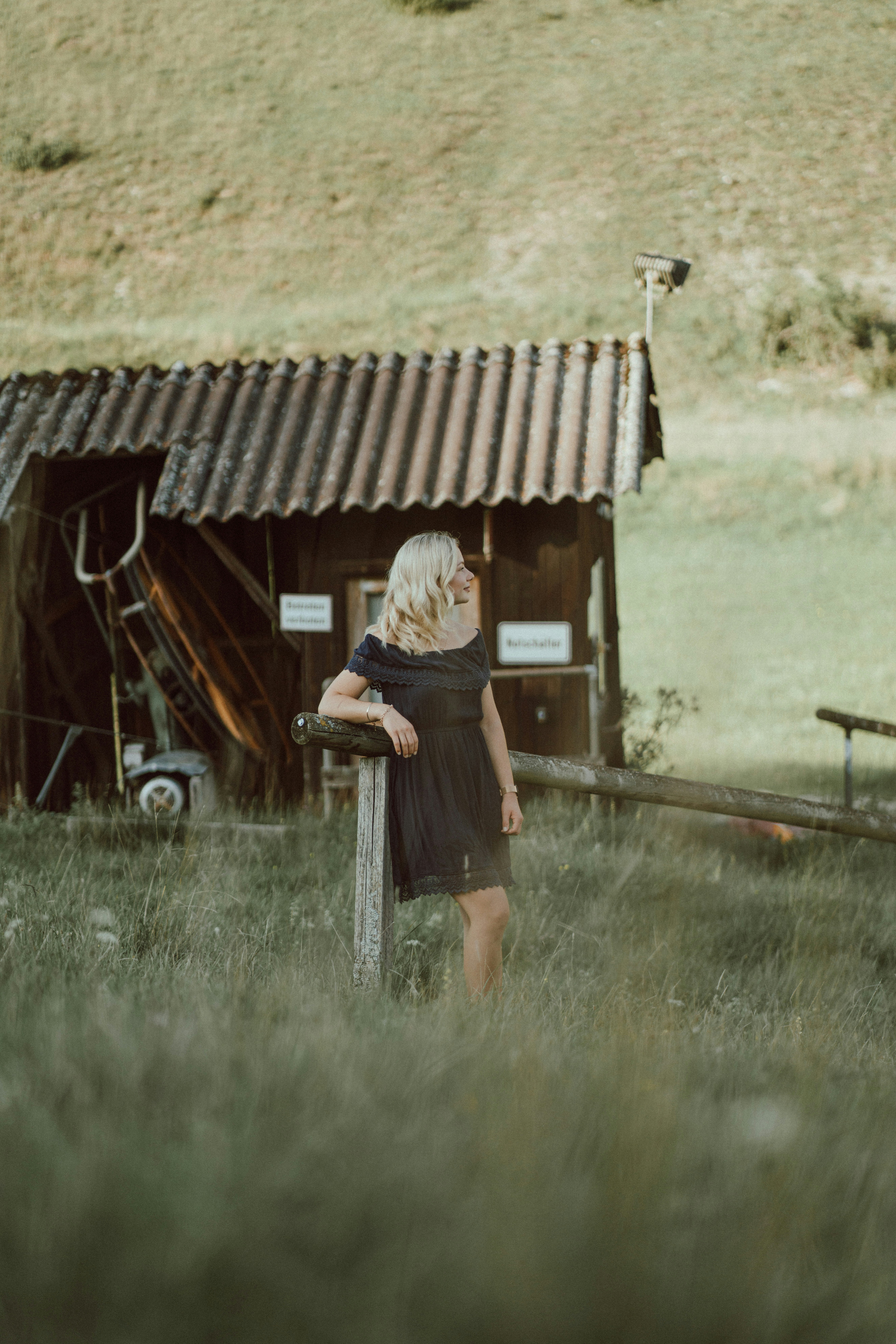 a woman in a black dress standing in a field