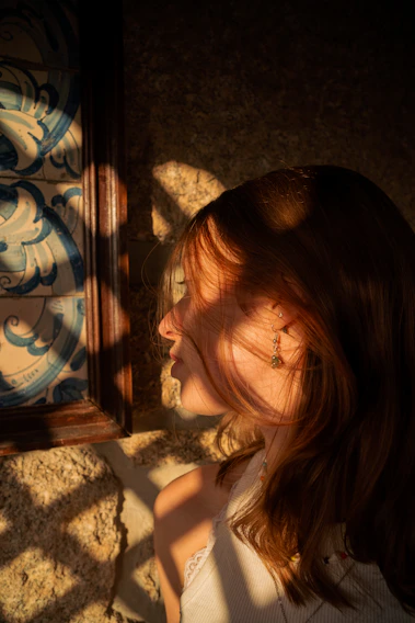 Portrait of a woman standing by golden hour light, capturing emotion and detail.