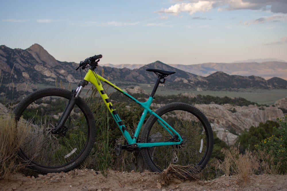 a blue and yellow mountain bike parked on top of a hill