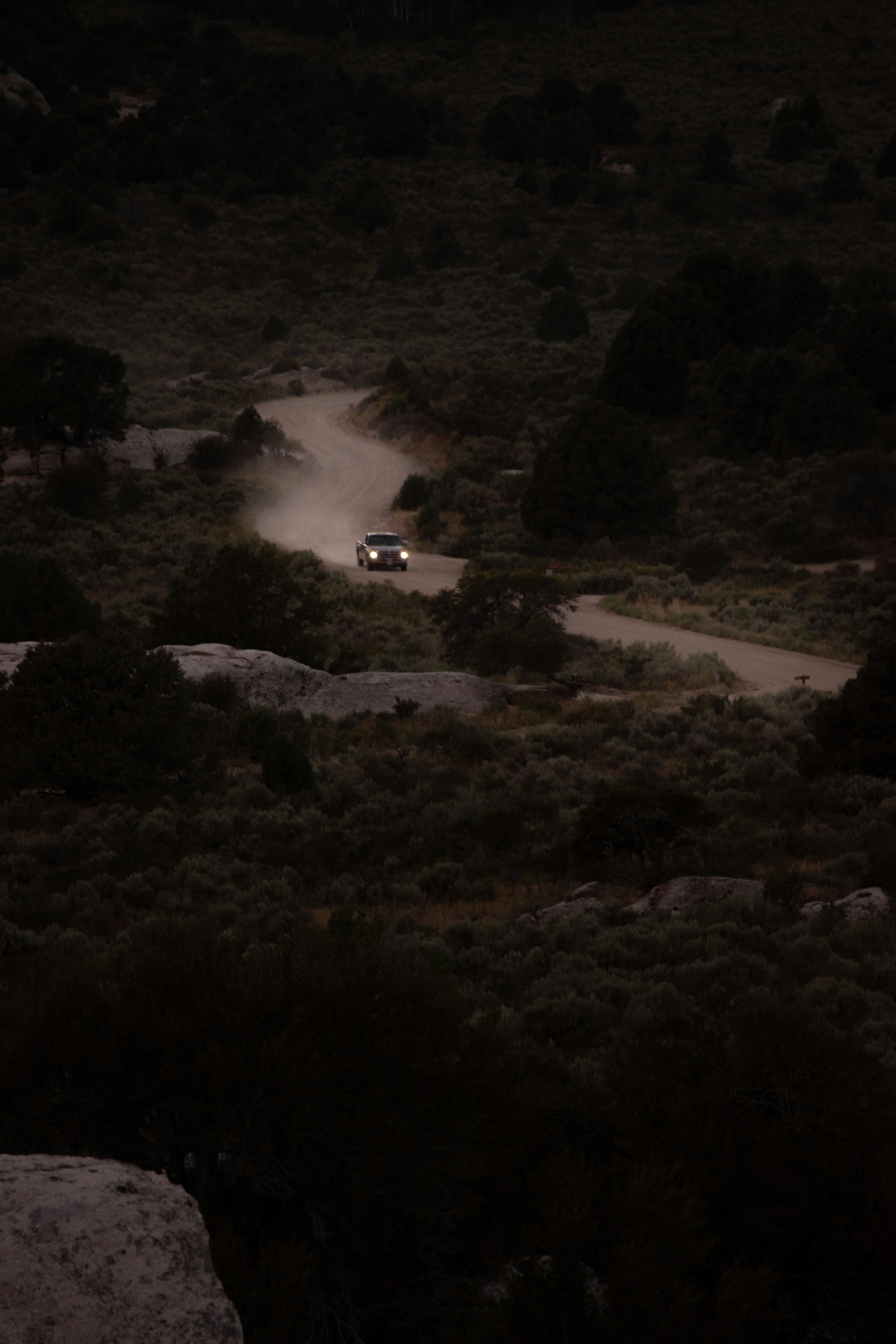 ein Auto, das nachts eine unbefestigte Straße hinunterfährt