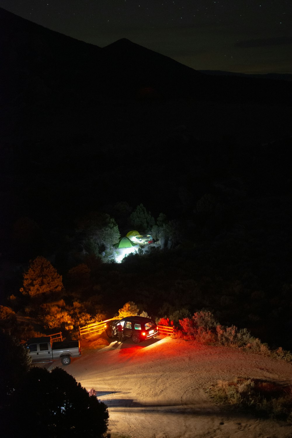 a couple of trucks parked in a parking lot at night