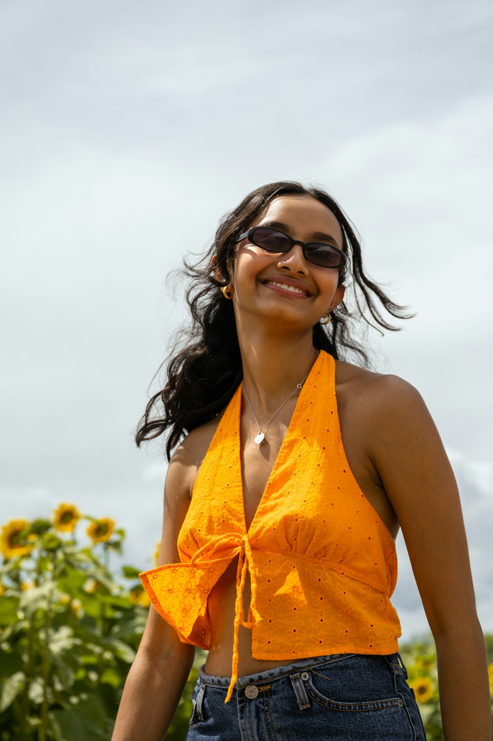 a woman wearing a yellow top and sunglasses