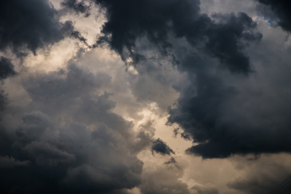 a plane flying through a cloudy sky on a cloudy day