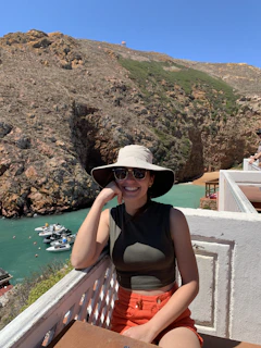 Happy guest smiling while enjoying a sunny balcony view at a charming rental.