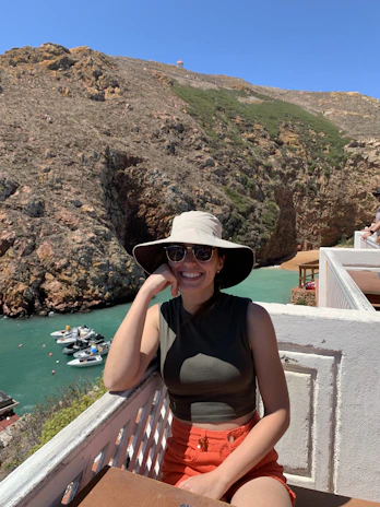 Happy guest smiling while enjoying a sunny balcony view at a charming rental.