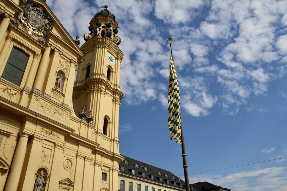 Un gran edificio con una torre del reloj y una bandera
