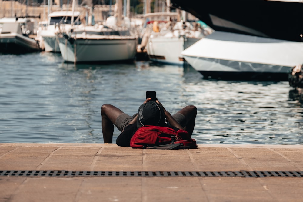 a person laying on the ground next to a body of water