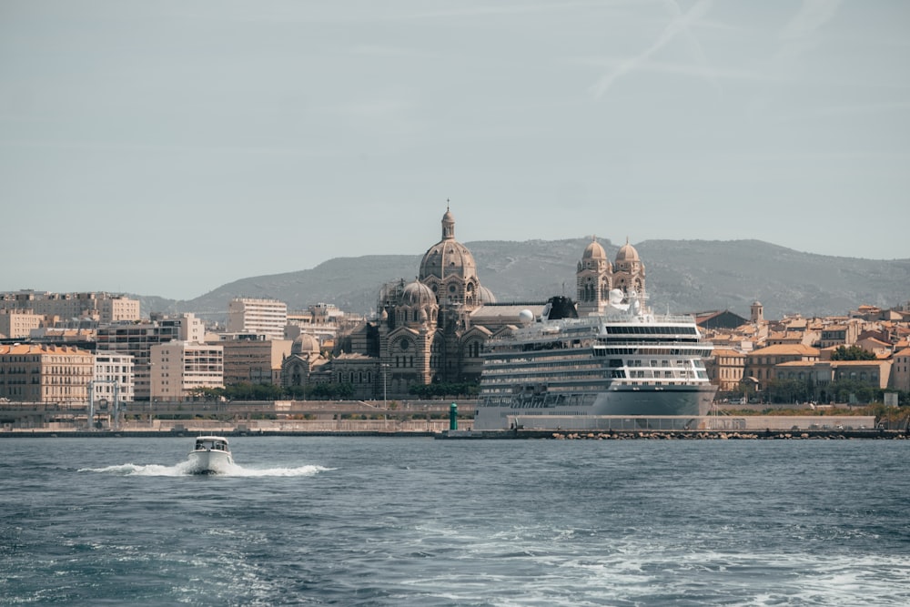 a cruise ship in the water with a city in the background