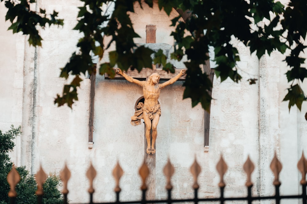a statue of jesus on a cross in front of a building