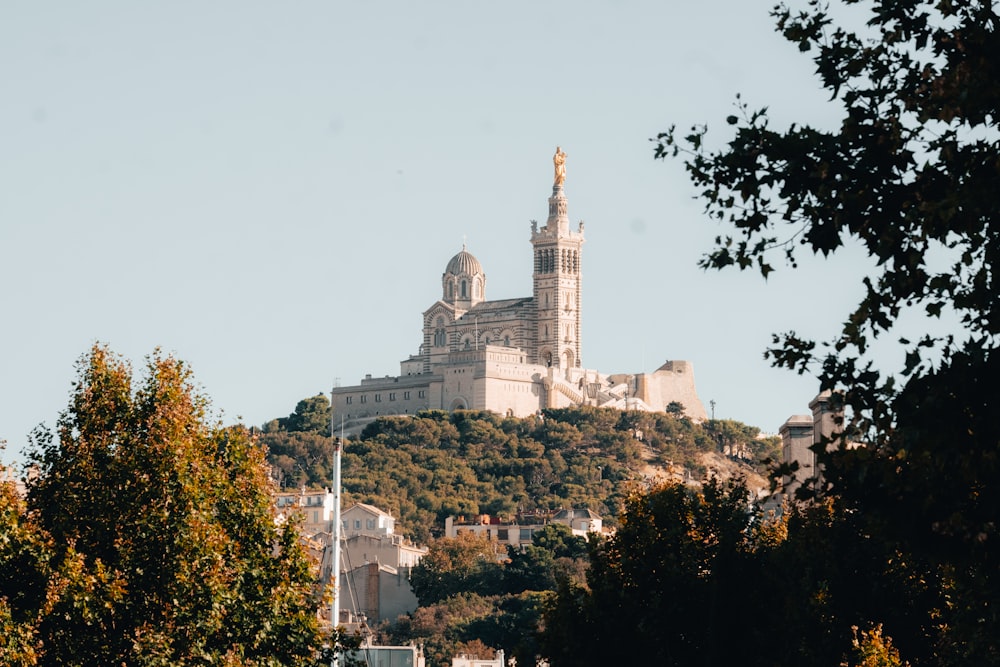 a large building on top of a hill surrounded by trees