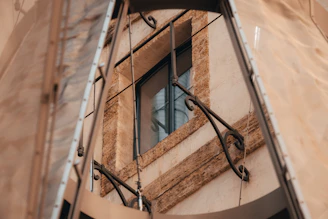 Modern metal window frame installed on a rustic building, showing clean lines and sturdy construction.