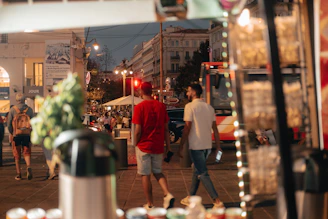 A vibrant street scene in Chennai with colorful food stalls and bustling pedestrians under evening lights.