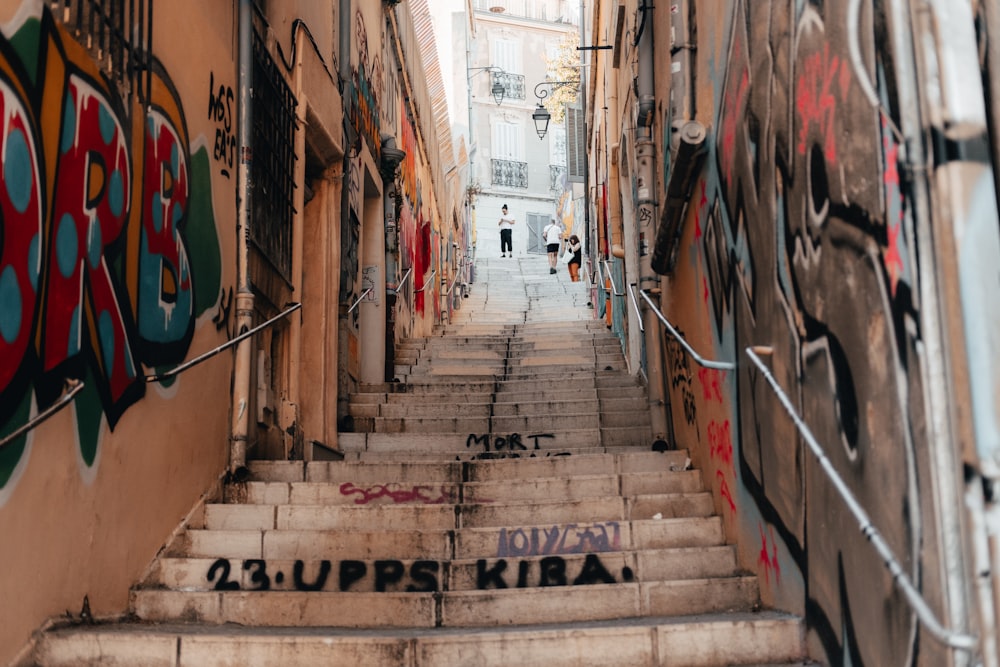 a narrow alley with graffiti on the walls