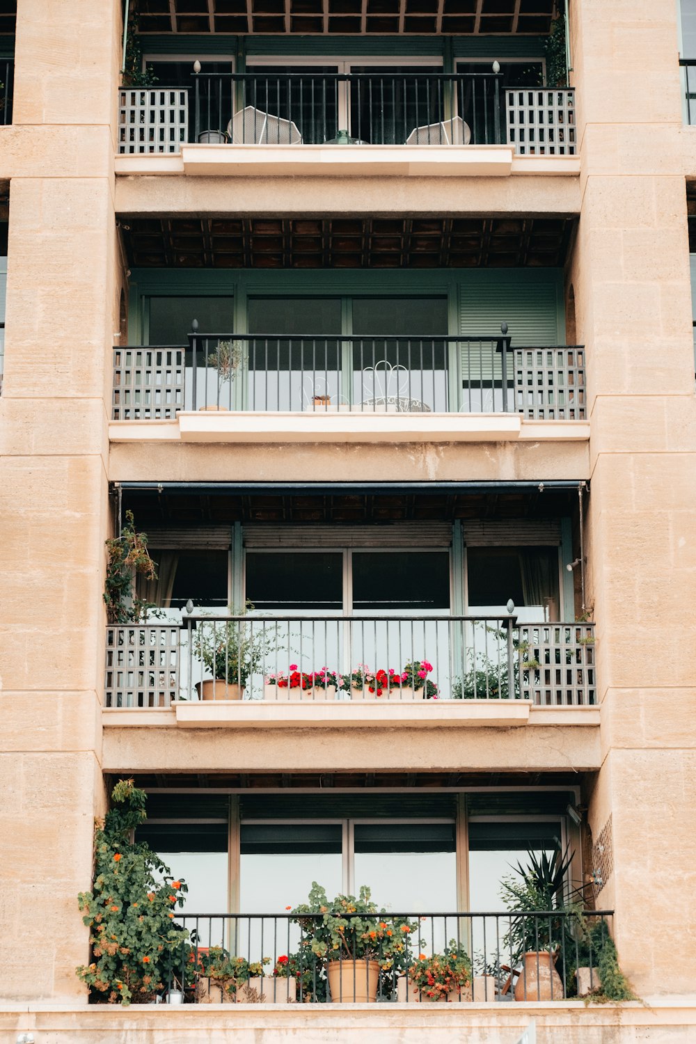a tall building with balconies and plants on the balconies