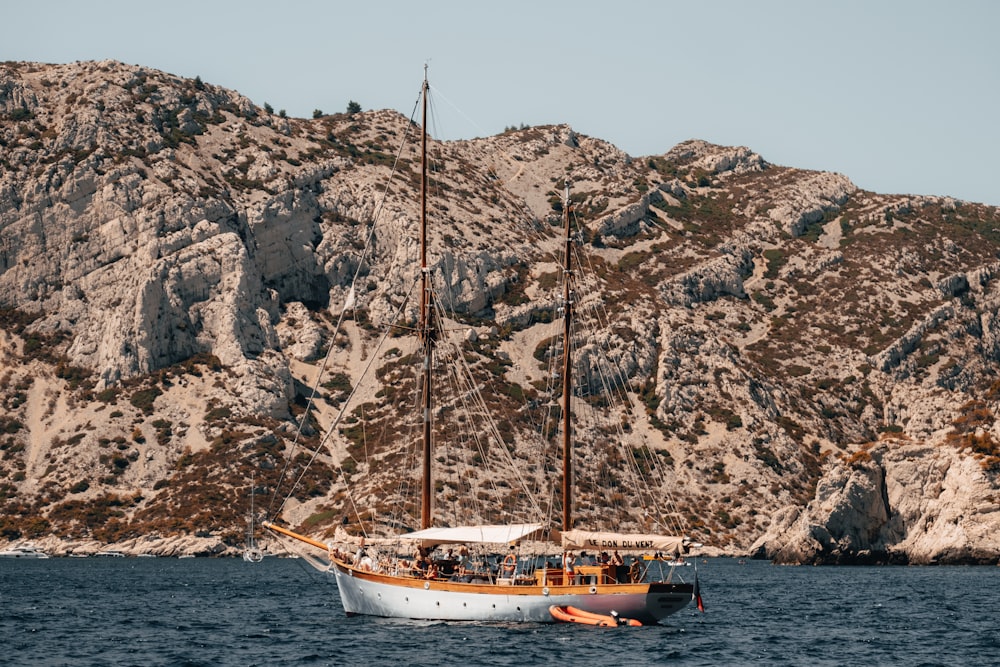 a sailboat in a body of water with a mountain in the background