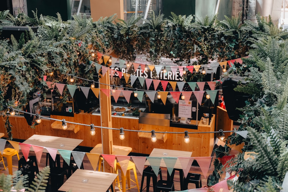 a restaurant with tables, chairs, and plants