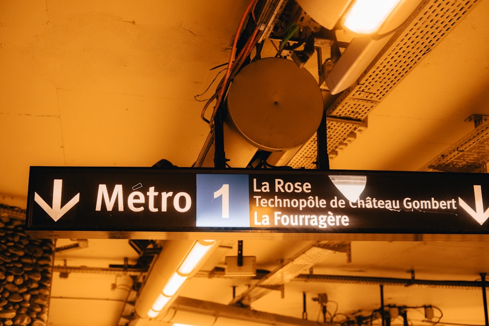 a metro sign hanging from the ceiling of a subway station