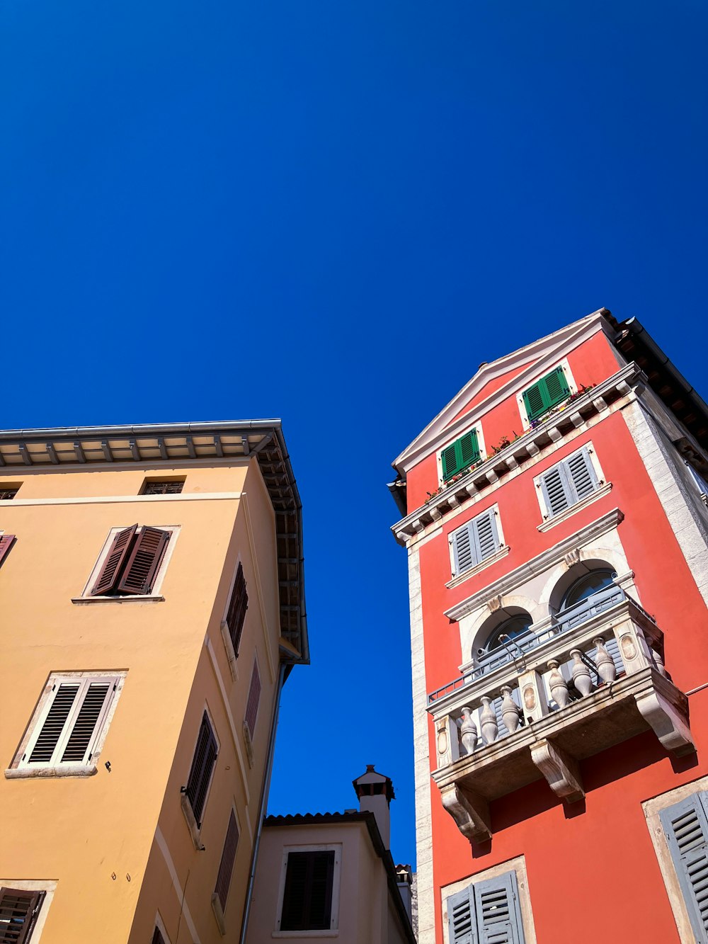 a red and yellow building next to a tan building