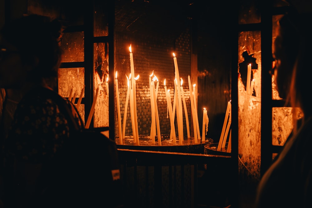 Un gruppo di persone in piedi davanti a un mucchio di candele accese