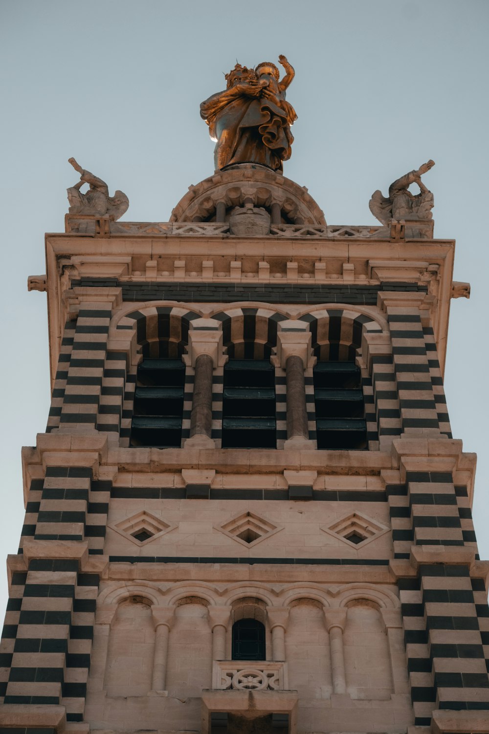 un'alta torre dell'orologio con una statua in cima