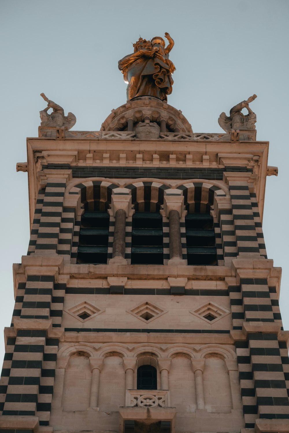 a tall clock tower with a statue on top of it