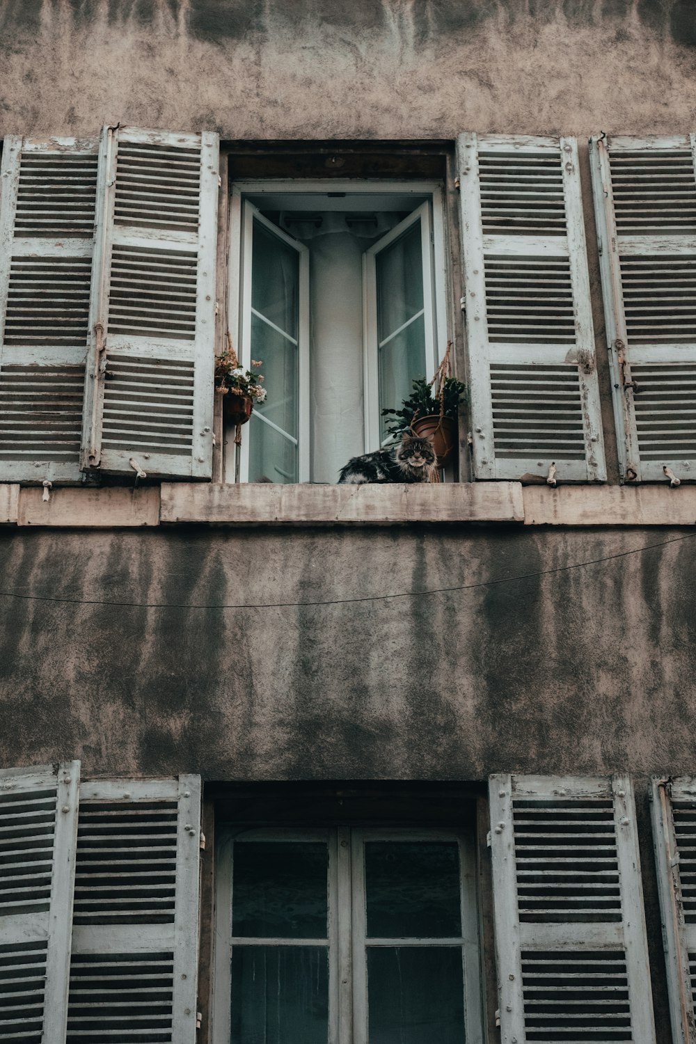 an old building with two windows and shutters