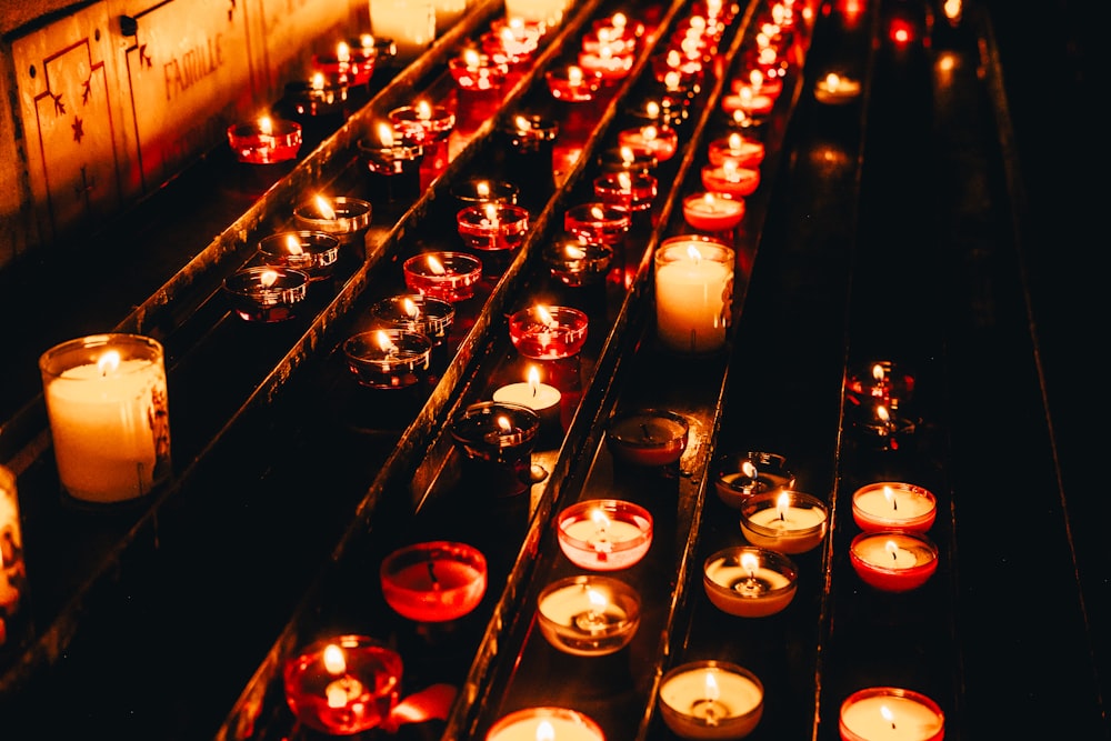 rows of lit candles in a dark room