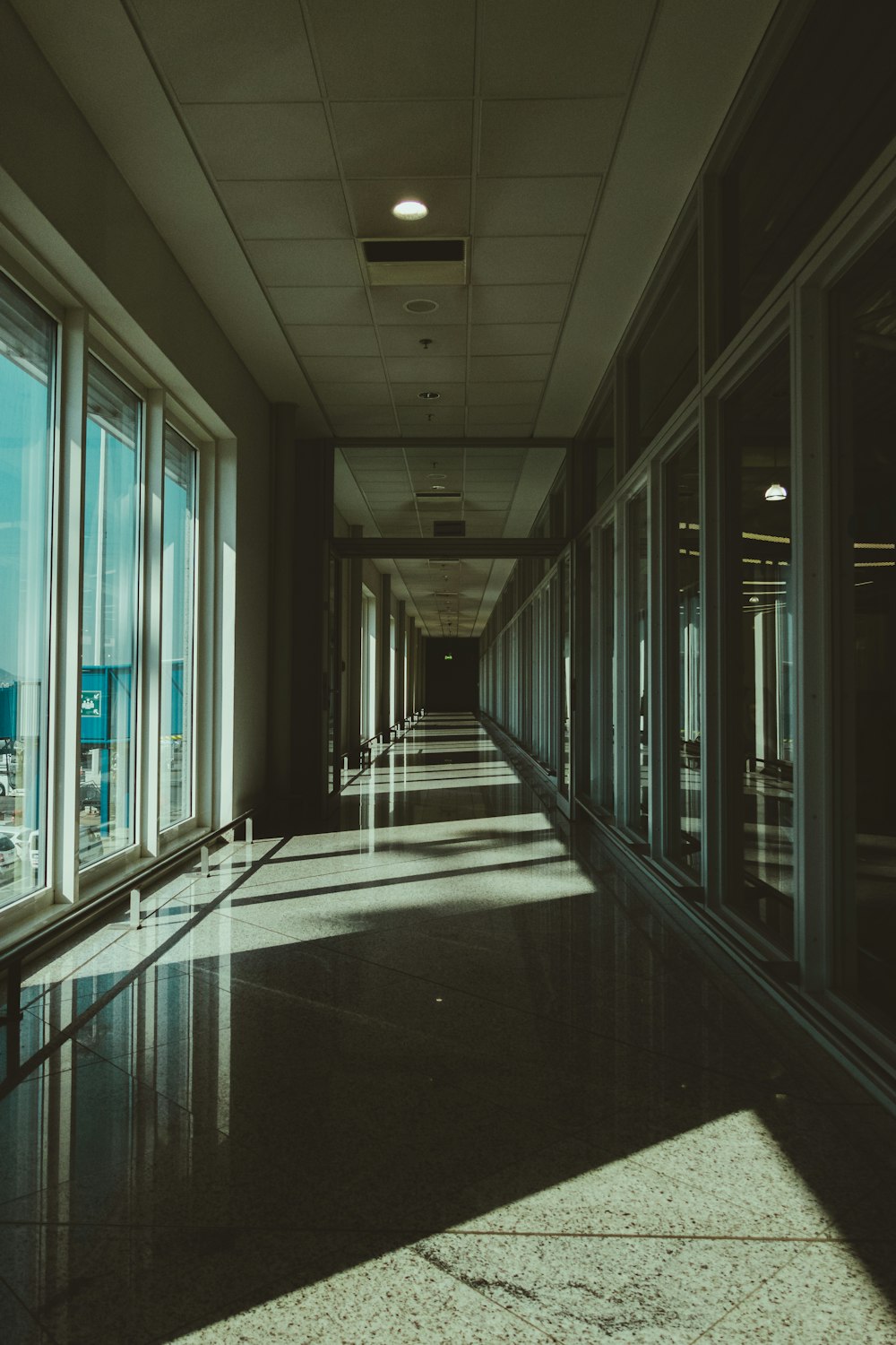 a long hallway with large windows leading to the sky