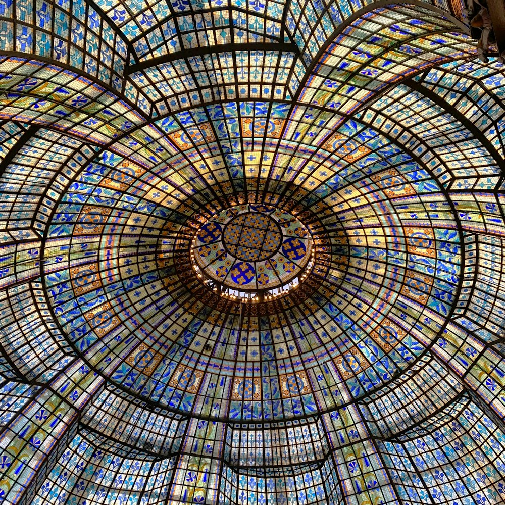 the ceiling of a building with a circular glass window