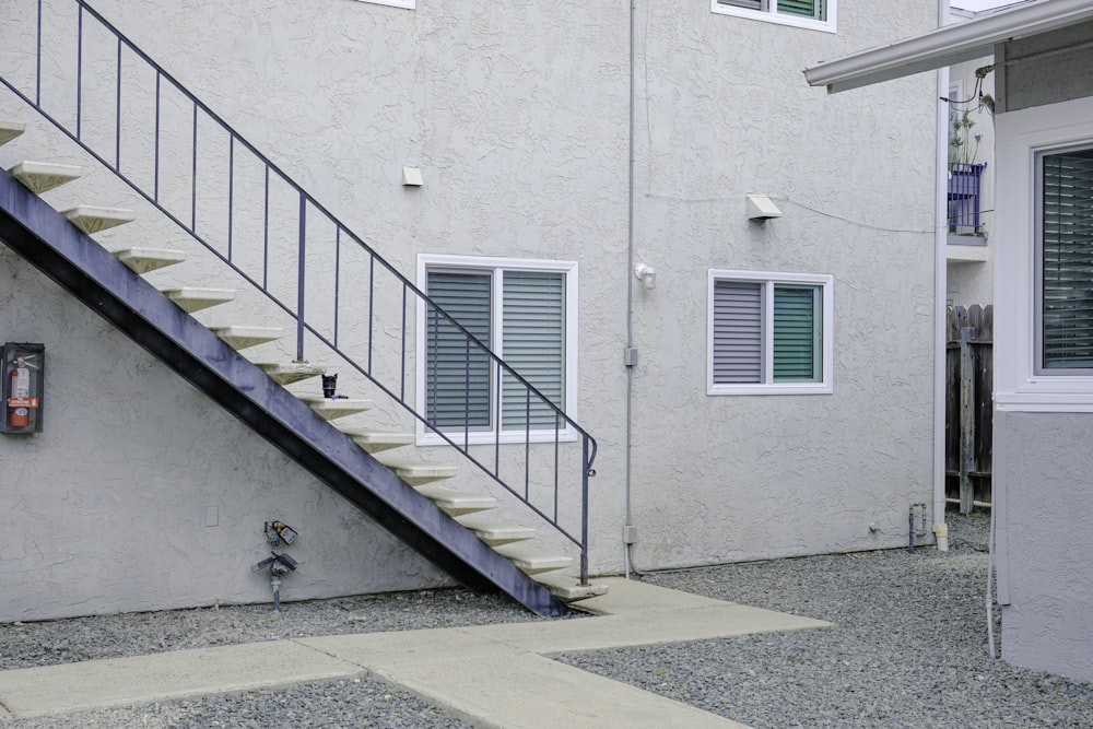 a white building with a stair case next to it