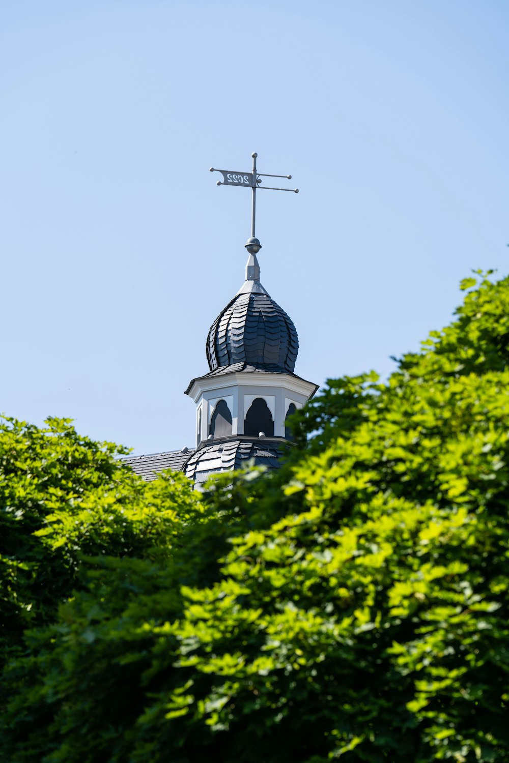 a tall tower with a weather vane on top of it