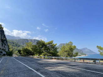 The Jaecoo J8 cruising along a coastal road with mountains in the background.