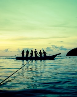 a group of people riding on top of a boat in the ocean