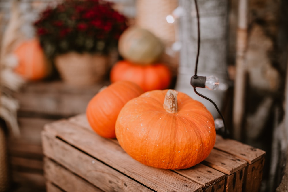 a couple of pumpkins sitting on top of a wooden crate