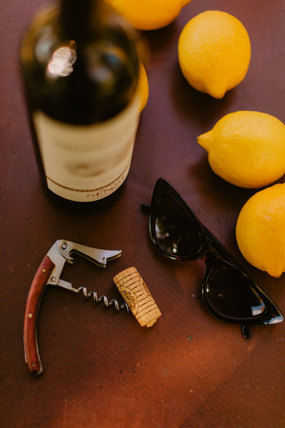 a bottle of wine, sunglasses, corkscrew, and a corkscrew