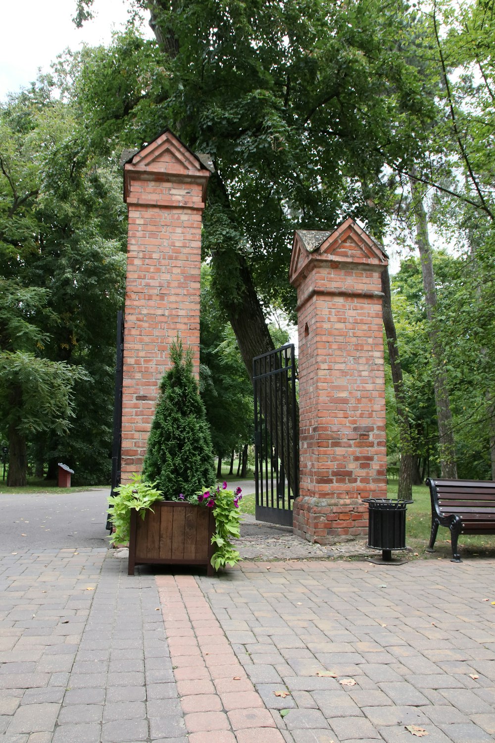 a couple of brick pillars sitting next to a tree