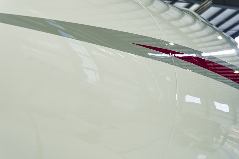 a close up of a white car with a red stripe